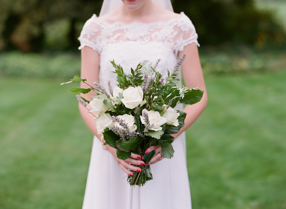 A bride wearing fresh flowers in her hair for her colourful English country garden wedding. Dress by Eponine London and photography by Rosie Anderson. eponine london, colourful wedding, english country garden wedding, rosemary anderson photography, flowers in her hair