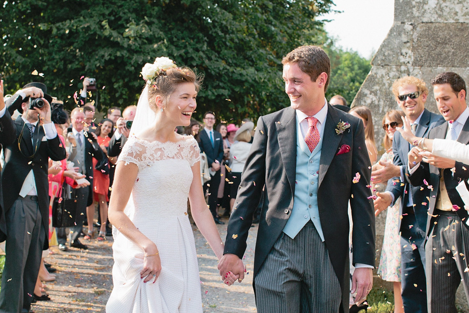 A bride wearing fresh flowers in her hair for her colourful English country garden wedding. Dress by Eponine London and photography by Rosie Anderson. eponine london, colourful wedding, english country garden wedding, rosemary anderson photography, flowers in her hair