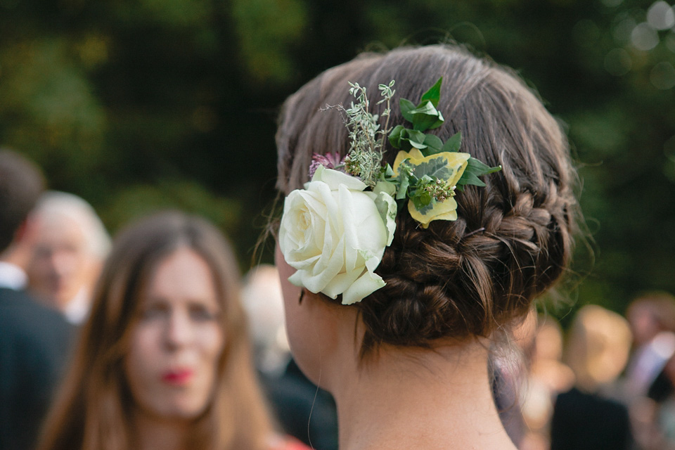 A bride wearing fresh flowers in her hair for her colourful English country garden wedding. Dress by Eponine London and photography by Rosie Anderson. eponine london, colourful wedding, english country garden wedding, rosemary anderson photography, flowers in her hair