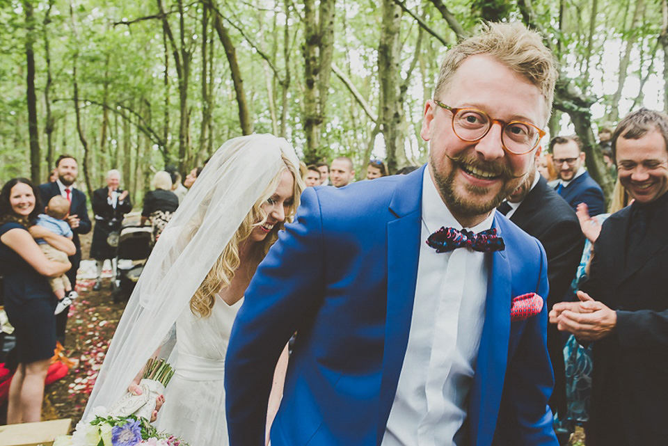 A boho bride wearing a Charlie Brear dress and veil for her woodland festival wedding at Hawthbush Farm in Sussex. Photography by Modern Vintage Weddings.