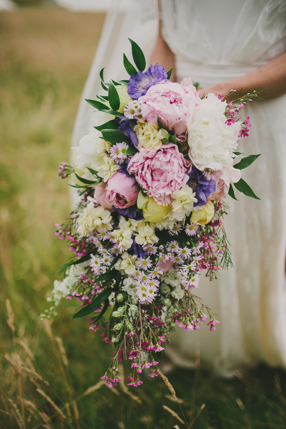 A boho bride wearing a Charlie Brear dress and veil for her woodland festival wedding at Hawthbush Farm in Sussex. Photography by Modern Vintage Weddings.