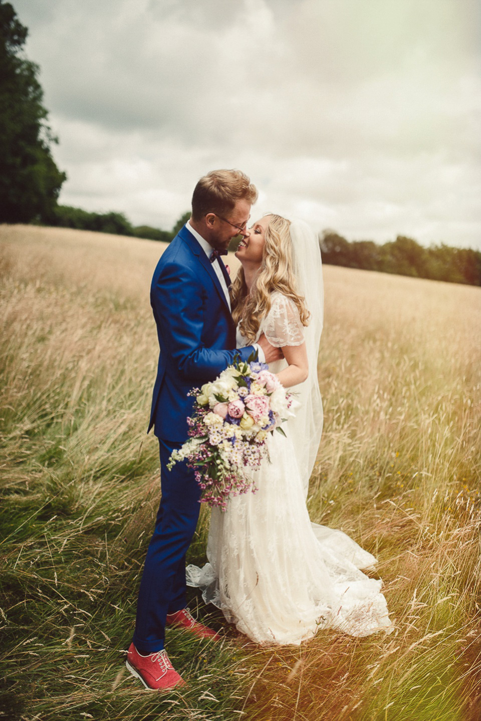 A boho bride wearing a Charlie Brear dress and veil for her woodland festival wedding at Hawthbush Farm in Sussex. Photography by Modern Vintage Weddings.