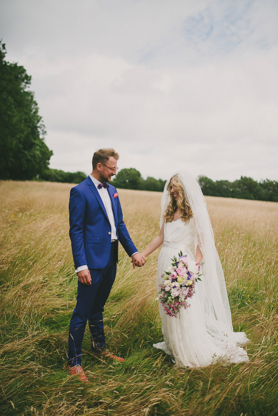 A boho bride wearing a Charlie Brear dress and veil for her woodland festival wedding at Hawthbush Farm in Sussex. Photography by Modern Vintage Weddings.