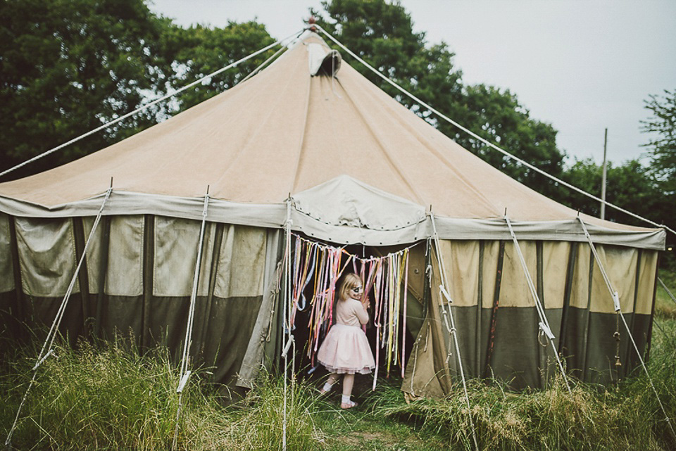 A boho bride wearing a Charlie Brear dress and veil for her woodland festival wedding at Hawthbush Farm in Sussex. Photography by Modern Vintage Weddings.