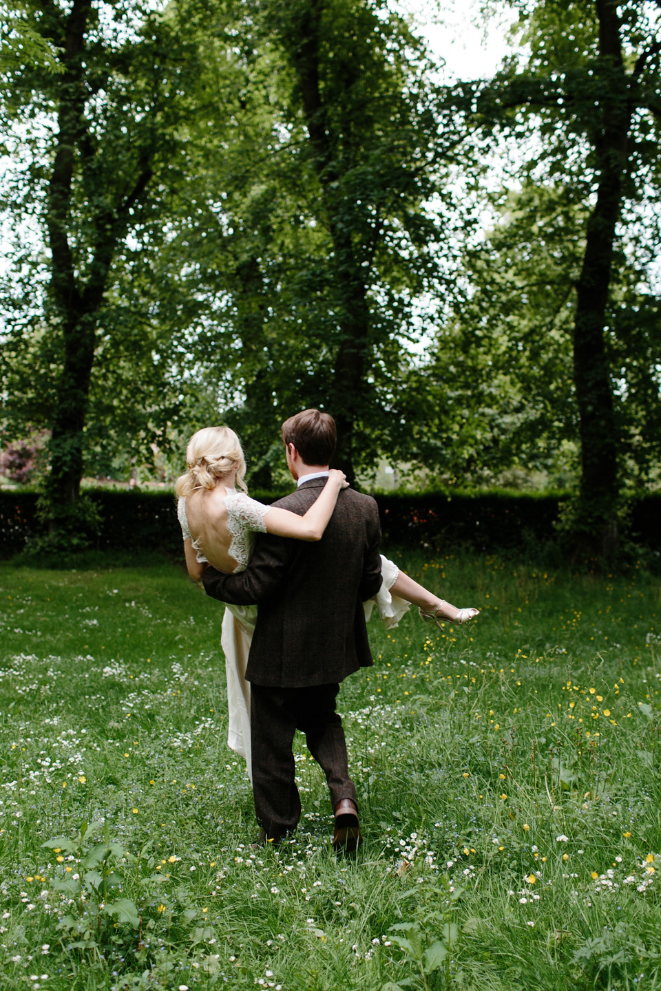 The bride wears a Rowanjoy dress and rose gold Twigs and Honey headpiece for her June wedding in Scotland. Photography by Caro Weiss.