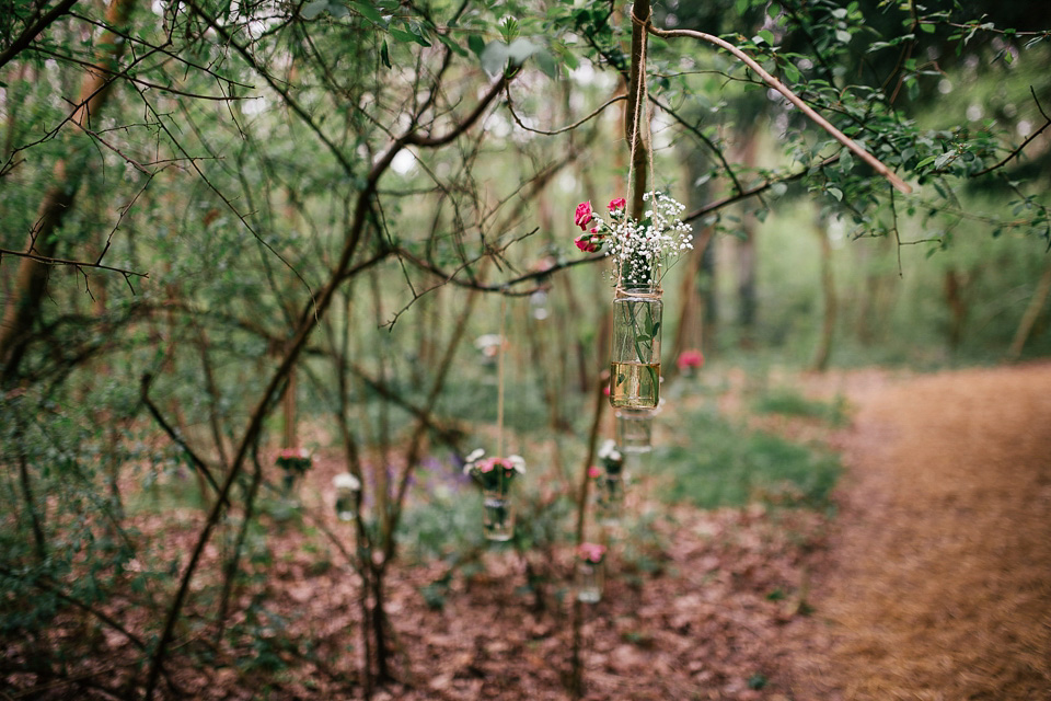 The bride wears a Sabina Motasem gown for her rustic, festival style wedding with glamping near the forrest. Photography by Joanna Nicole.