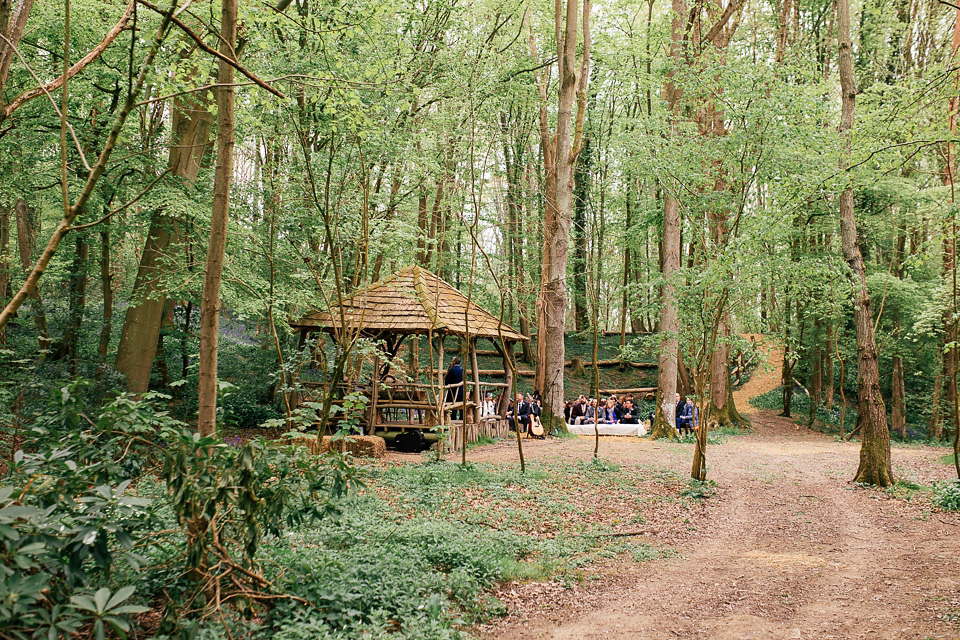 The bride wears a Sabina Motasem gown for her rustic, festival style wedding with glamping near the forrest. Photography by Joanna Nicole.