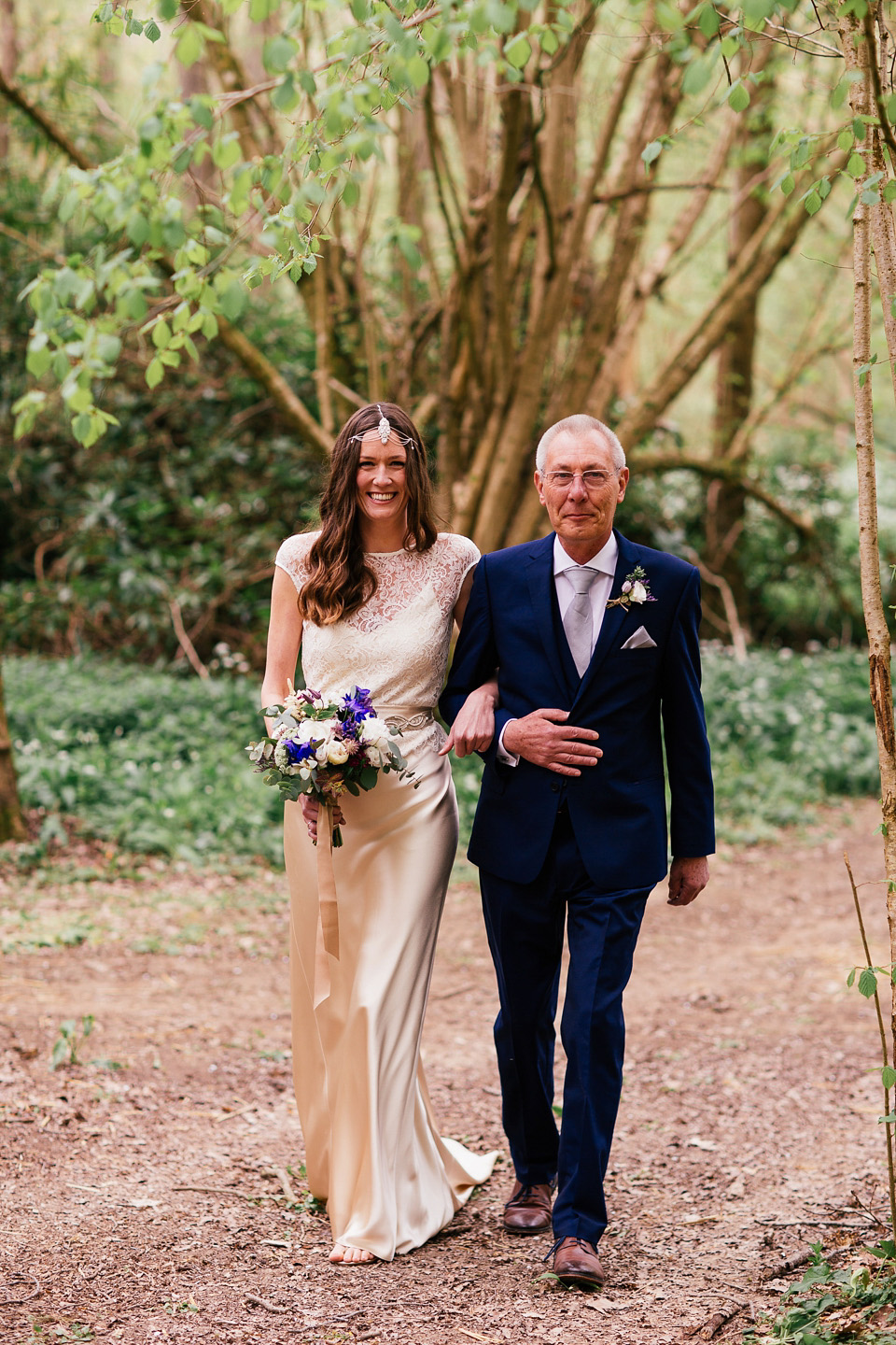 The bride wears a Sabina Motasem gown for her rustic, festival style wedding with glamping near the forrest. Photography by Joanna Nicole.