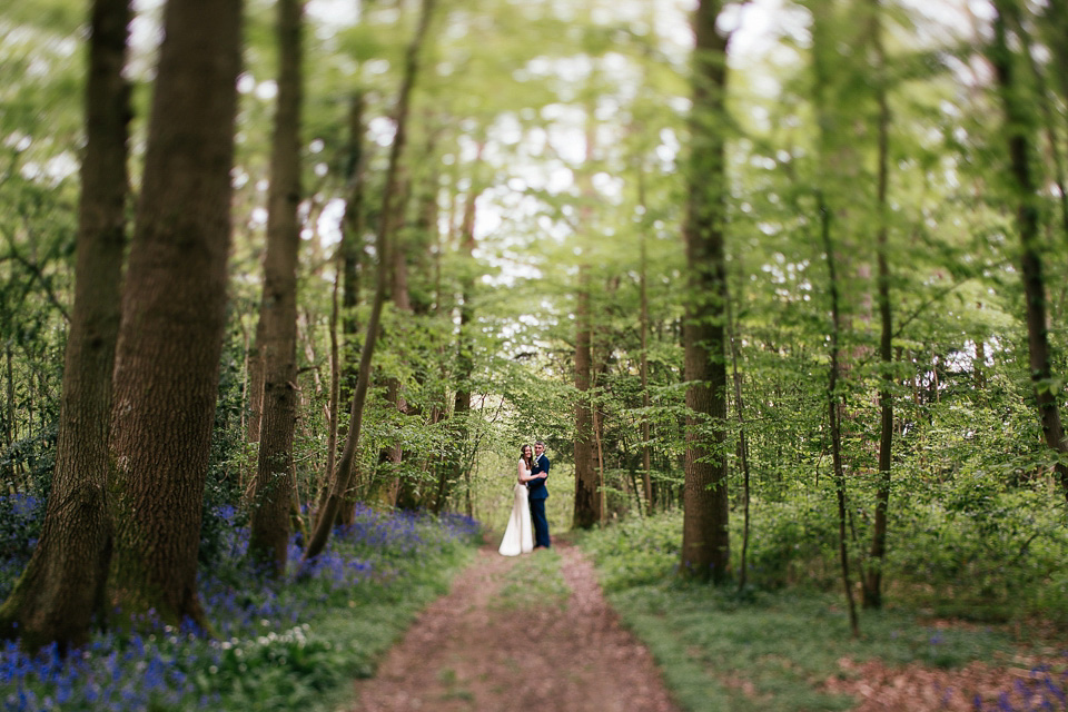 The bride wears a Sabina Motasem gown for her rustic, festival style wedding with glamping near the forrest. Photography by Joanna Nicole.