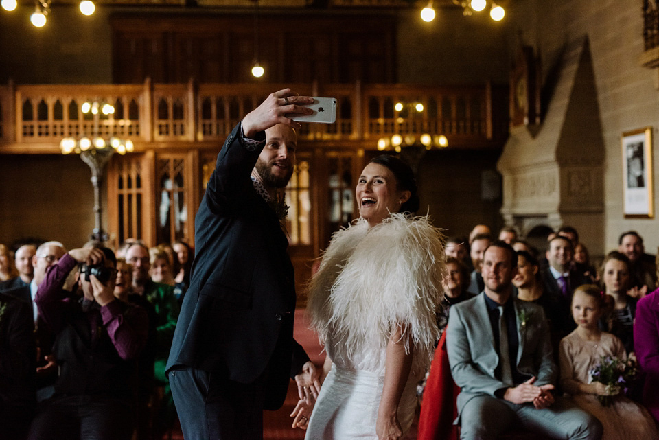 The bride wears a drop waist 1920s style wedding dress by Charlie Brear for her Manchester city wedding. Photography by Neil Thomas Douglas