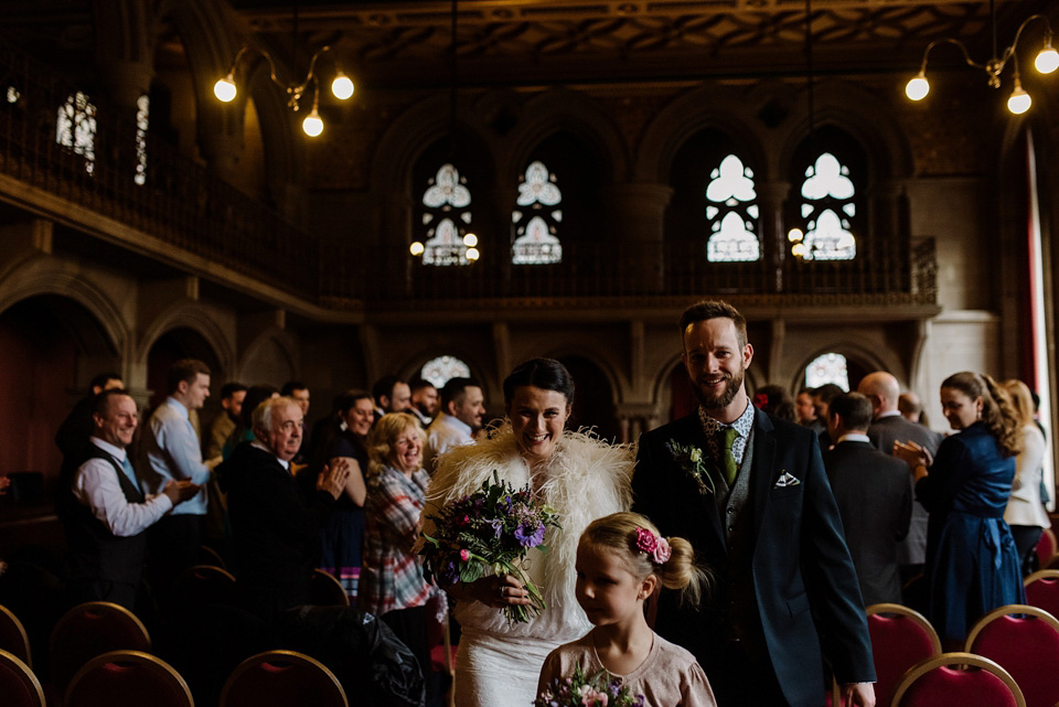 The bride wears a drop waist 1920s style wedding dress by Charlie Brear for her Manchester city wedding. Photography by Neil Thomas Douglas