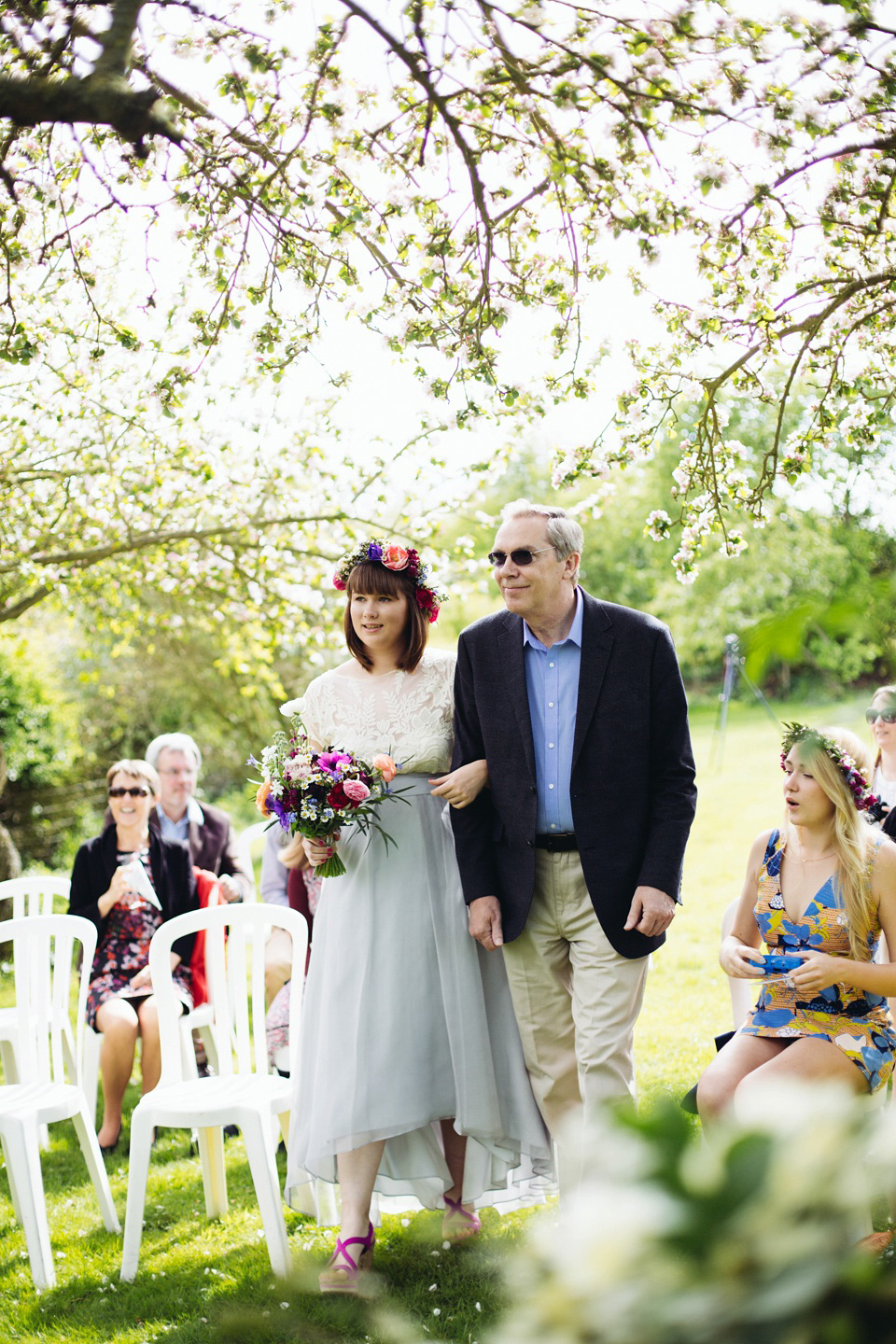 The bride wears a top and skirt for her charming orchard wedding. Photography by Cat Lane.