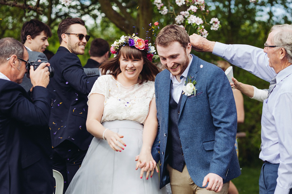 The bride wears a top and skirt for her charming orchard wedding. Photography by Cat Lane.