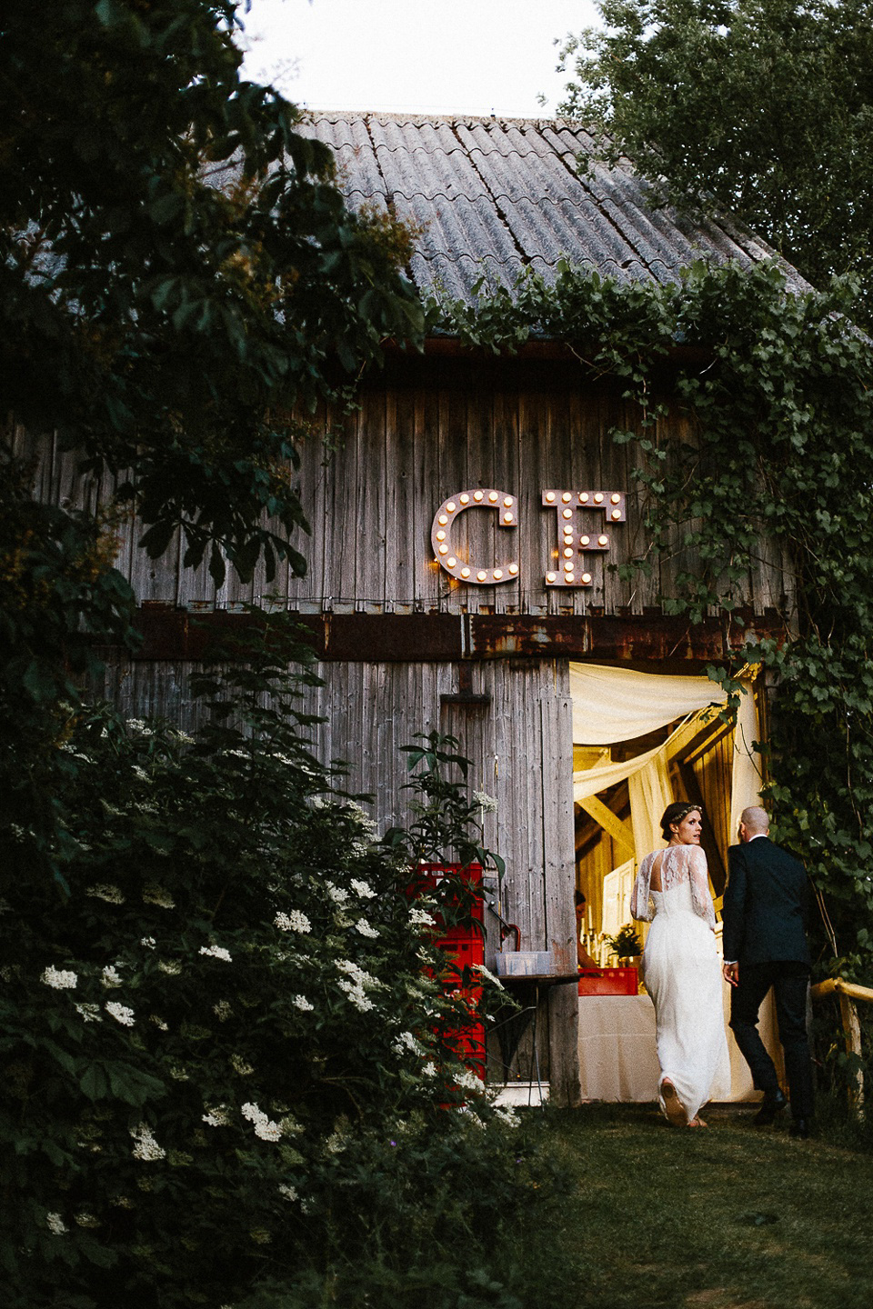 The bride wears Sarah Seven and a Ru de Seine lace blouse for her Boho Rustic Bavarian Farmhouse wedding. Photography by Kevin Klein.