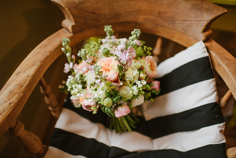 The bride wears a customised Alice & Olivia dress and 1950s wax flower headpiece for her Springtime village hall wedding. Photography by Ellie Gillard.