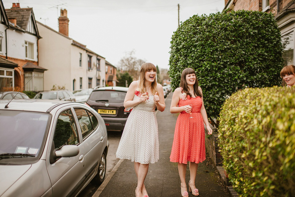 The bride wears a customised Alice & Olivia dress and 1950s wax flower headpiece for her Springtime village hall wedding. Photography by Ellie Gillard.