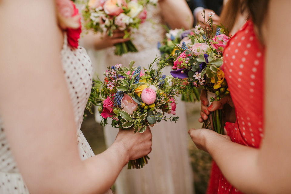 The bride wears a customised Alice & Olivia dress and 1950s wax flower headpiece for her Springtime village hall wedding. Photography by Ellie Gillard.