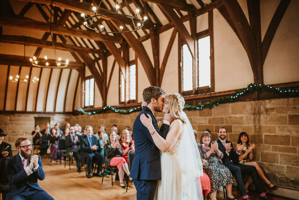 The bride wears a customised Alice & Olivia dress and 1950s wax flower headpiece for her Springtime village hall wedding. Photography by Ellie Gillard.