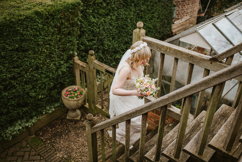 The bride wears a customised Alice & Olivia dress and 1950s wax flower headpiece for her Springtime village hall wedding. Photography by Ellie Gillard.