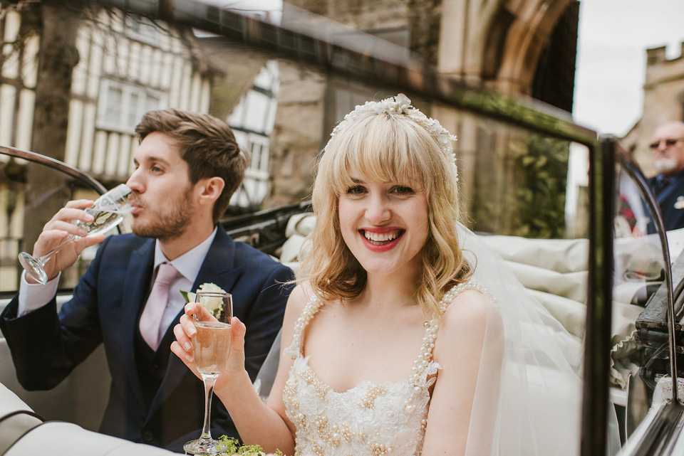 The bride wears a customised Alice & Olivia dress and 1950s wax flower headpiece for her Springtime village hall wedding. Photography by Ellie Gillard.