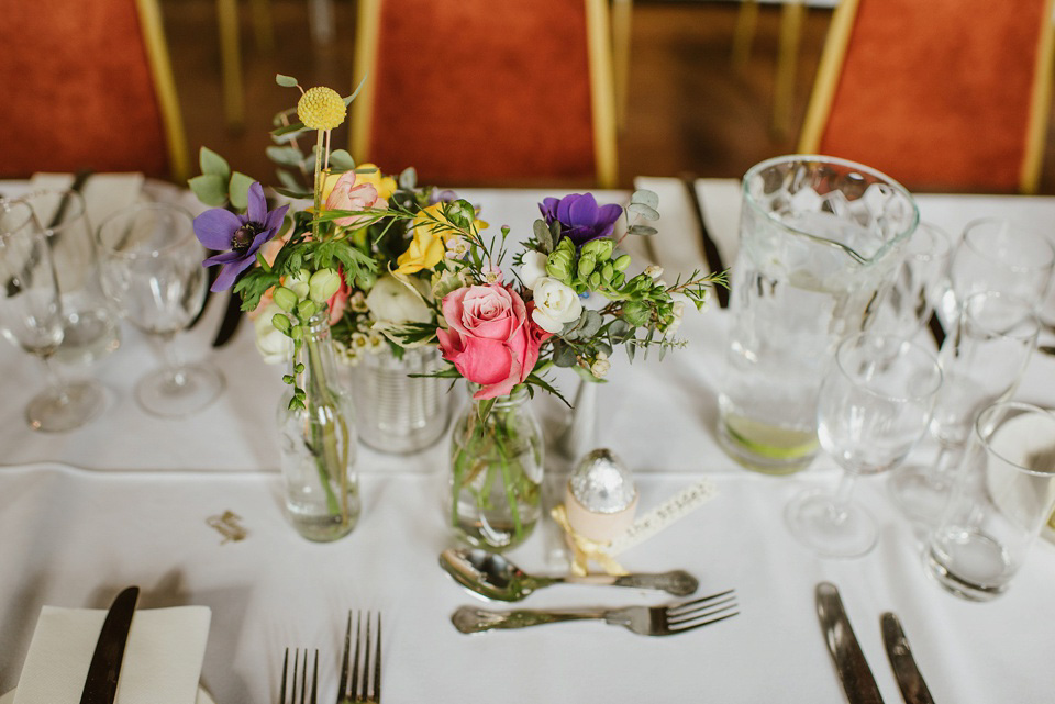 The bride wears a customised Alice & Olivia dress and 1950s wax flower headpiece for her Springtime village hall wedding. Photography by Ellie Gillard.