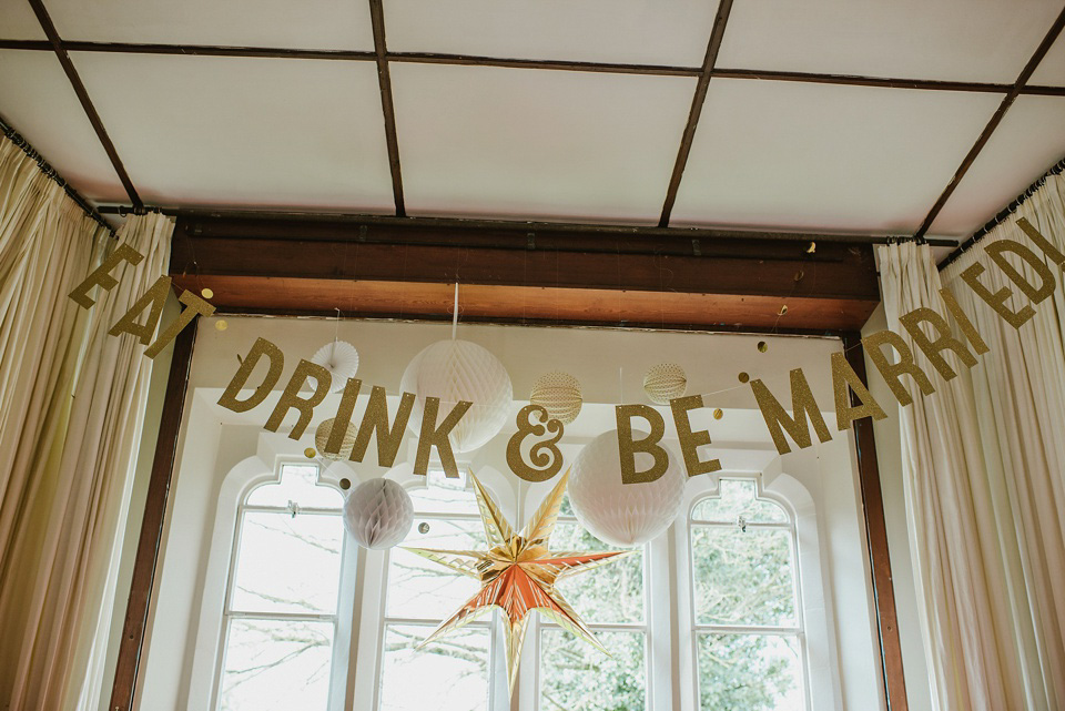 The bride wears a customised Alice & Olivia dress and 1950s wax flower headpiece for her Springtime village hall wedding. Photography by Ellie Gillard.