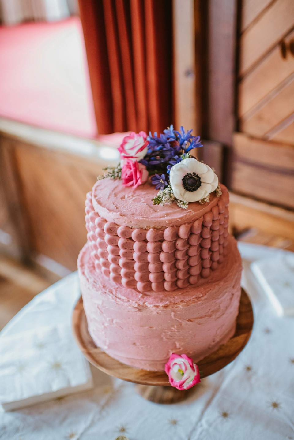 The bride wears a customised Alice & Olivia dress and 1950s wax flower headpiece for her Springtime village hall wedding. Photography by Ellie Gillard.