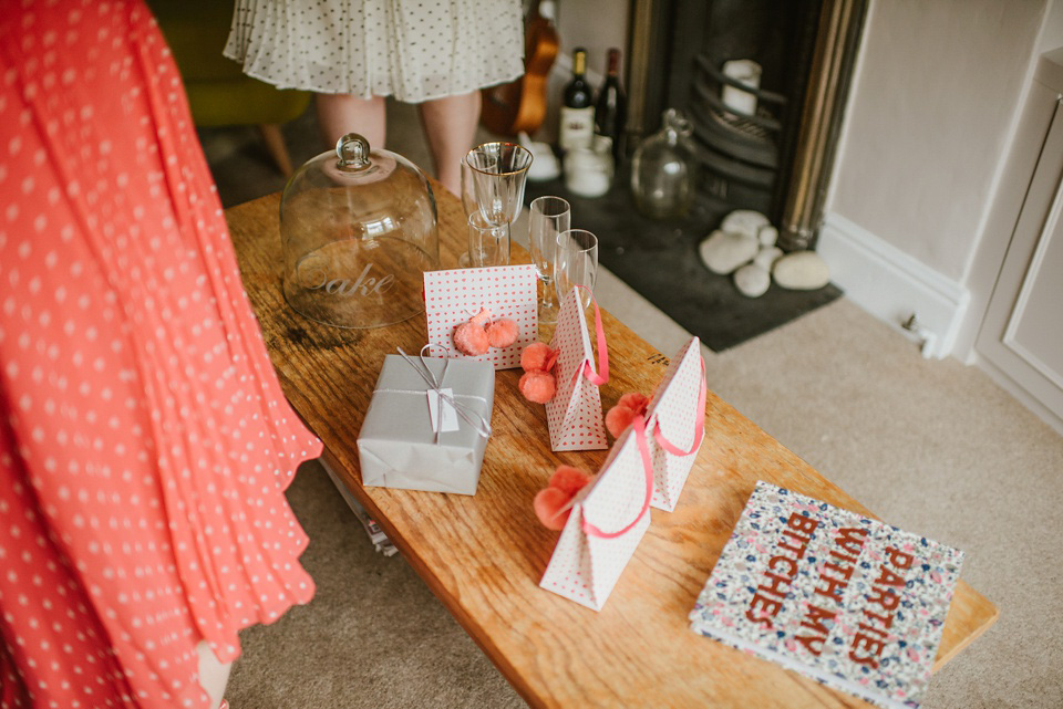 The bride wears a customised Alice & Olivia dress and 1950s wax flower headpiece for her Springtime village hall wedding. Photography by Ellie Gillard.