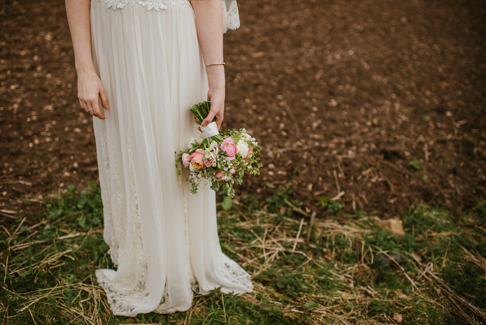 The bride wears a customised Alice & Olivia dress and 1950s wax flower headpiece for her Springtime village hall wedding. Photography by Ellie Gillard.