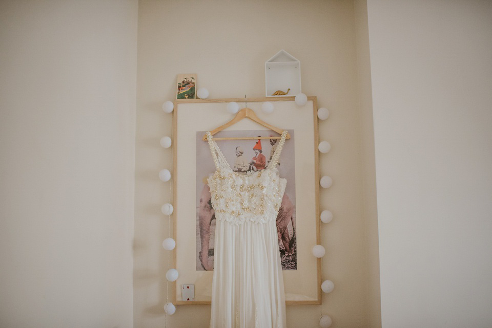 The bride wears a customised Alice & Olivia dress and 1950s wax flower headpiece for her Springtime village hall wedding. Photography by Ellie Gillard.