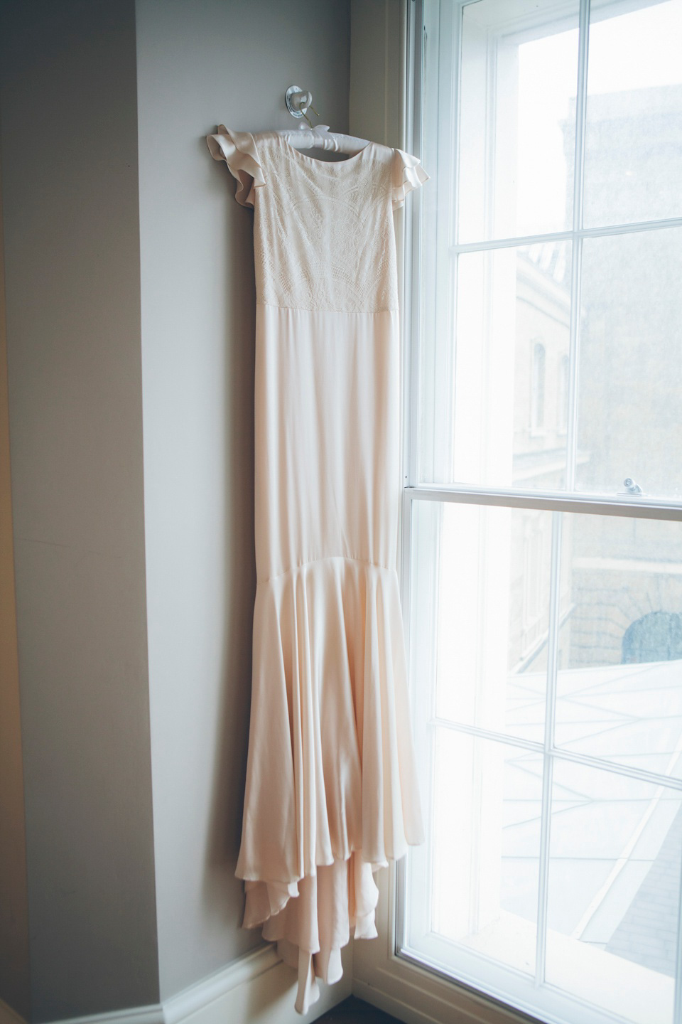 The bride wears a Belle & Bunty gown in blush for her child and family friendly wedding at Trinity Buoy Wharf in London. Photography by Kat Green.