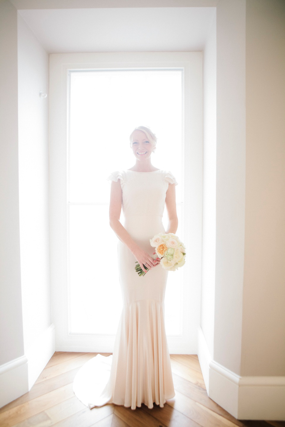 The bride wears a Belle & Bunty gown in blush for her child and family friendly wedding at Trinity Buoy Wharf in London. Photography by Kat Green.