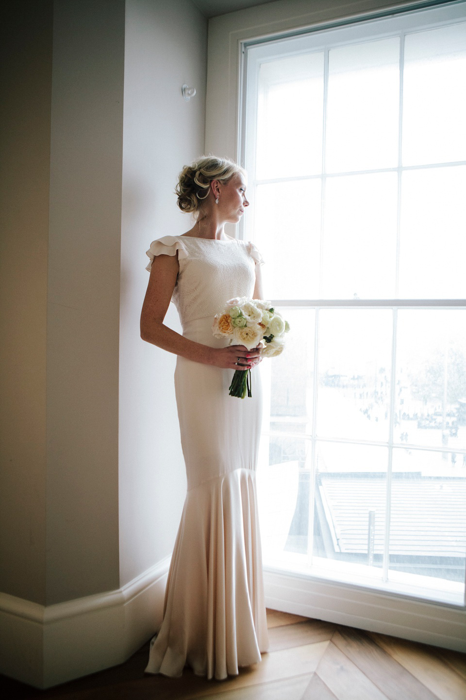 The bride wears a Belle & Bunty gown in blush for her child and family friendly wedding at Trinity Buoy Wharf in London. Photography by Kat Green.