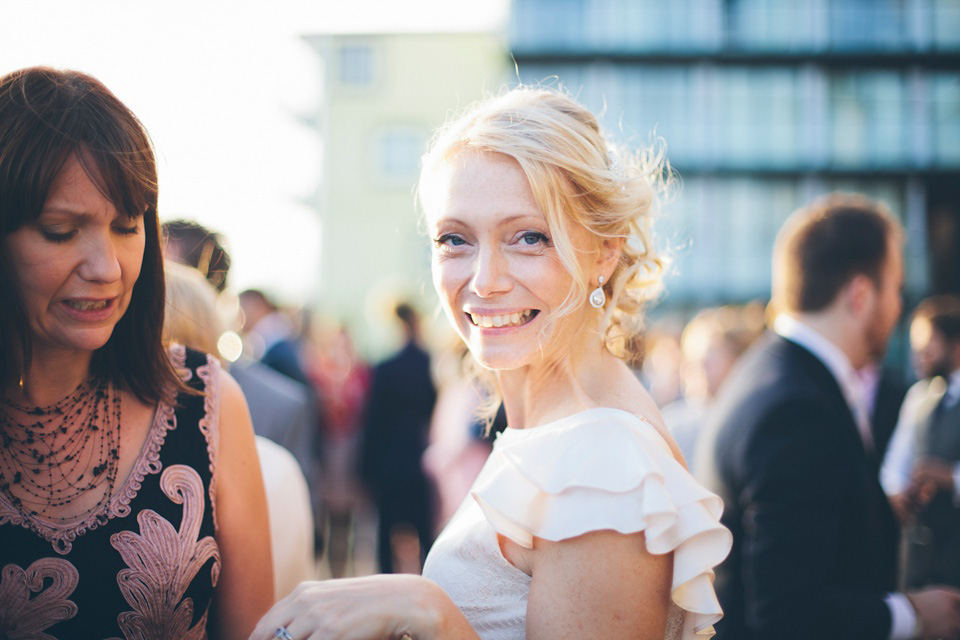 The bride wears a Belle & Bunty gown in blush for her child and family friendly wedding at Trinity Buoy Wharf in London. Photography by Kat Green.