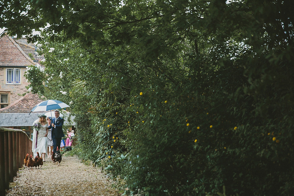 The bride wears a beautiful floral crown and Charlie Brear dress for her house party wedding at Maunsel House in Somerset. Photography by McKinley Rodgers.