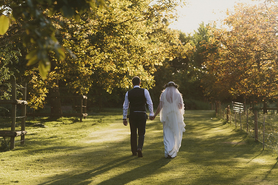 The bride wears a beautiful floral crown and Charlie Brear dress for her house party wedding at Maunsel House in Somerset. Photography by McKinley Rodgers.