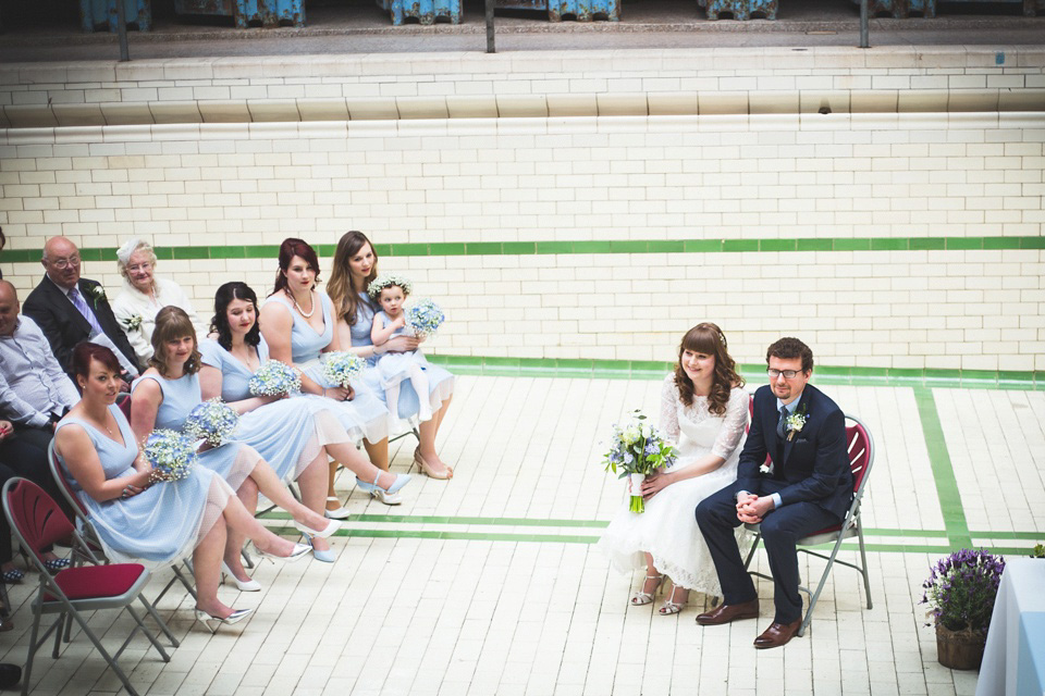 The bride wears a Charlotte Balbier gown for her 50's vintage inspired pale blue wedding at Victoria Baths, Manchester.