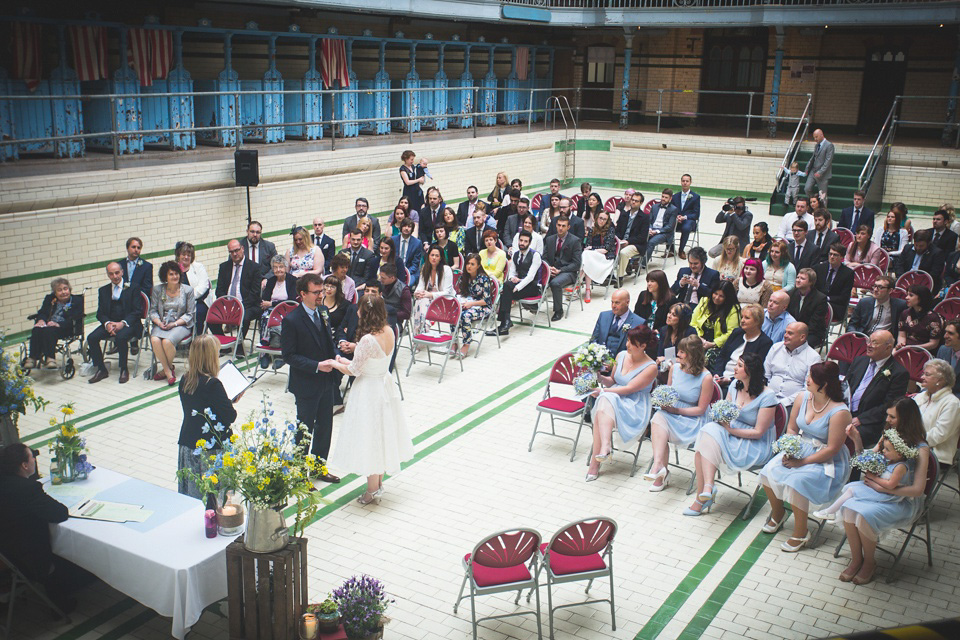 The bride wears a Charlotte Balbier gown for her 50's vintage inspired pale blue wedding at Victoria Baths, Manchester.