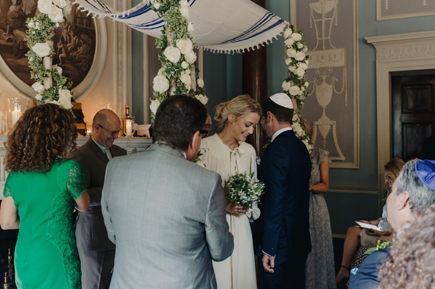 Bride Jess wears an original 1970's vintage Ossie Clarke dress for her Jewish wedding ceremony at Home House in London. Photography by Rebecca Goddard.