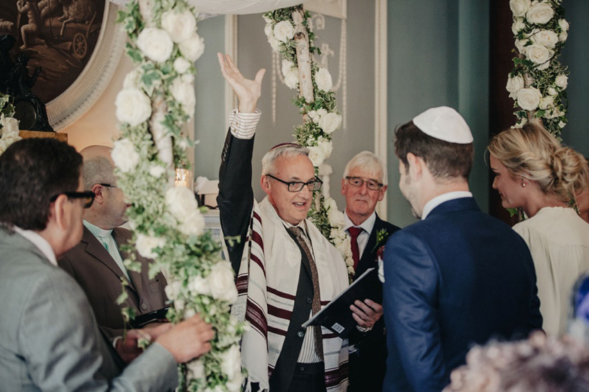 Bride Jess wears an original 1970's vintage Ossie Clarke dress for her Jewish wedding ceremony at Home House in London. Photography by Rebecca Goddard.