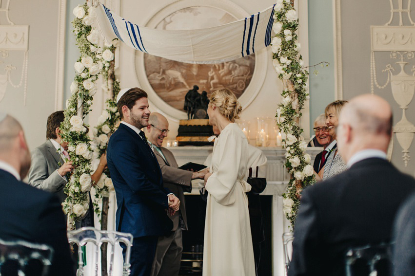 Bride Jess wears an original 1970's vintage Ossie Clarke dress for her Jewish wedding ceremony at Home House in London. Photography by Rebecca Goddard.