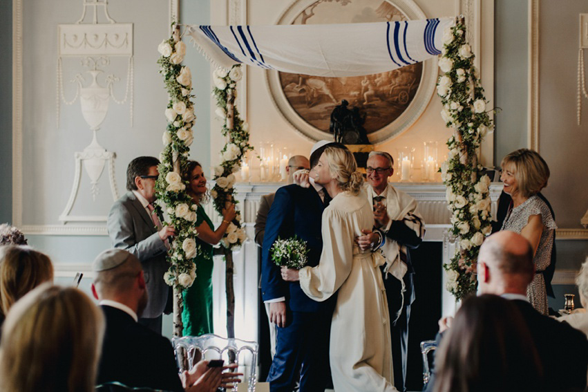 Bride Jess wears an original 1970's vintage Ossie Clarke dress for her Jewish wedding ceremony at Home House in London. Photography by Rebecca Goddard.