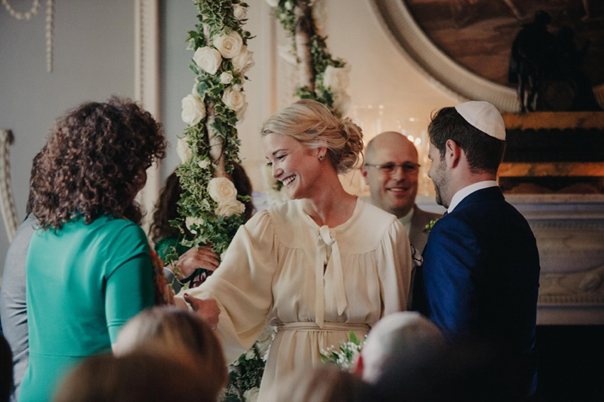 Bride Jess wears an original 1970's vintage Ossie Clarke dress for her Jewish wedding ceremony at Home House in London. Photography by Rebecca Goddard.