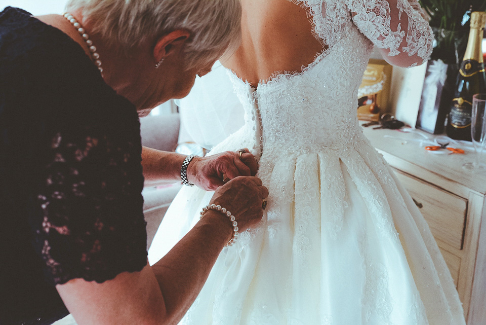 The bride wears a 1950's inspired lace dress for her village hall wedding in Yorkshire. Photography by Shutter Go Click.