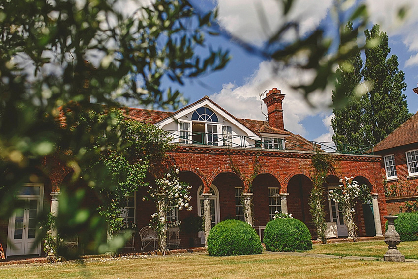 The bride wore a Watters wedding dress for her wedding at The Great Barn at Micklefield Hall in Hertfordshire. The bridesmaids wore navy blue. Photography by Benjamin Stuart.