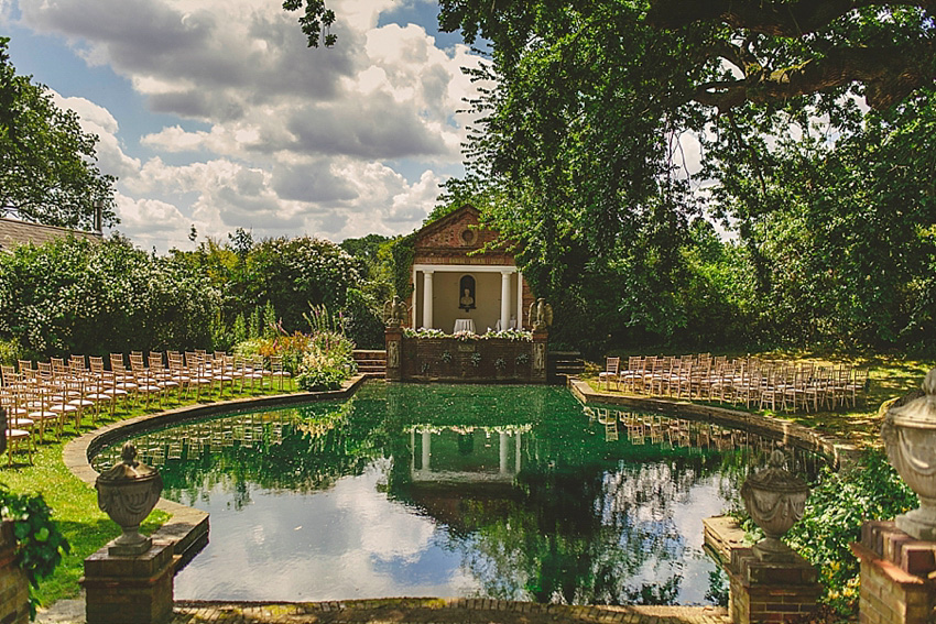 The bride wore a Watters wedding dress for her wedding at The Great Barn at Micklefield Hall in Hertfordshire. The bridesmaids wore navy blue. Photography by Benjamin Stuart.