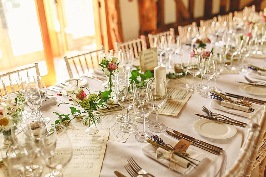 The bride wore a Watters wedding dress for her wedding at The Great Barn at Micklefield Hall in Hertfordshire. The bridesmaids wore navy blue. Photography by Benjamin Stuart.