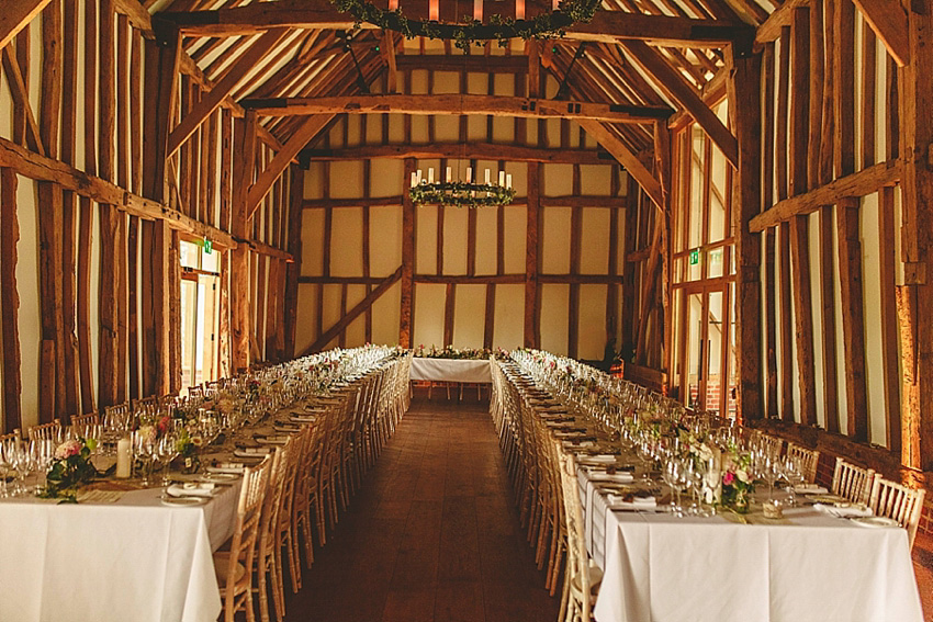 The bride wore a Watters wedding dress for her wedding at The Great Barn at Micklefield Hall in Hertfordshire. The bridesmaids wore navy blue. Photography by Benjamin Stuart.