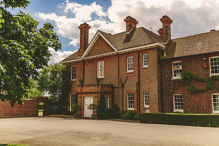 The bride wore a Watters wedding dress for her wedding at The Great Barn at Micklefield Hall in Hertfordshire. The bridesmaids wore navy blue. Photography by Benjamin Stuart.