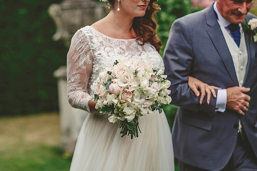 The bride wore a Watters wedding dress for her wedding at The Great Barn at Micklefield Hall in Hertfordshire. The bridesmaids wore navy blue. Photography by Benjamin Stuart.